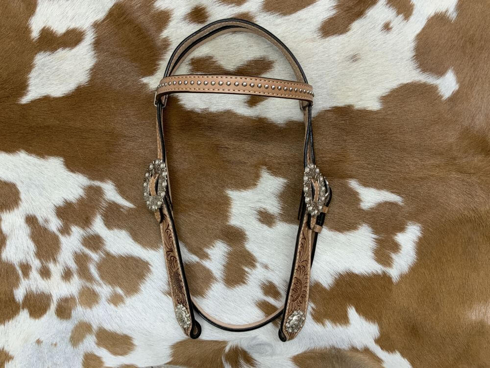 Circle S Barrel Saddle Set with Sunflower Tooling - front view headstall on printed background